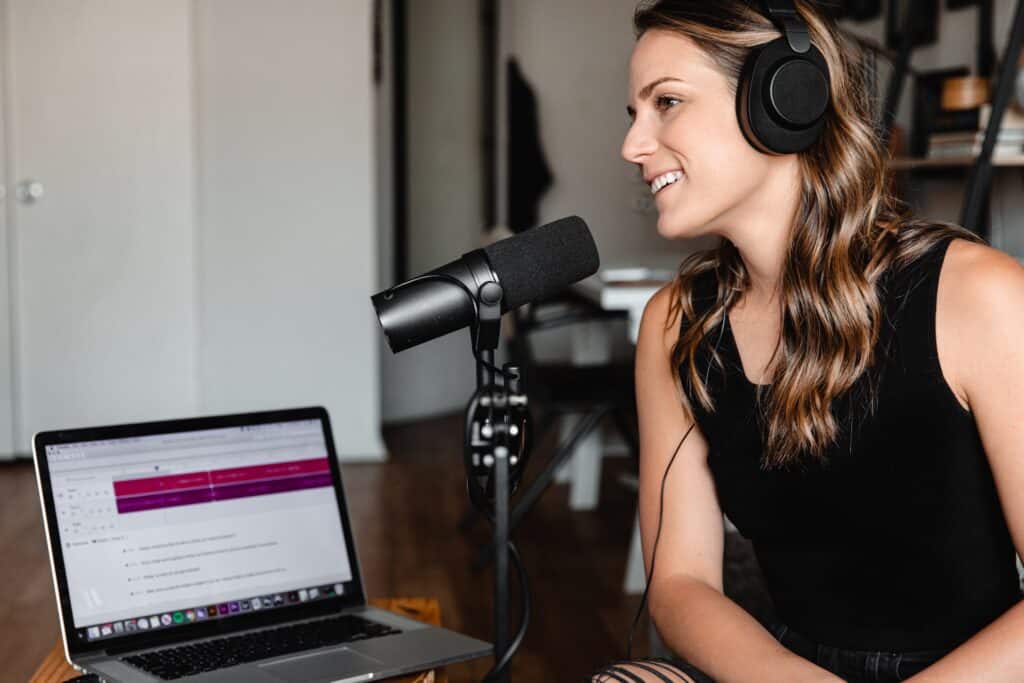 A young woman recording on a Shure SM7B while working remotely from home