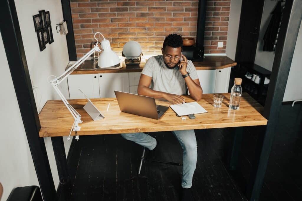 Man sitting and working at his home office desk with a laptop