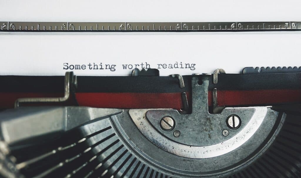 A typewriter with "Something worth reading" typed on a sheet of white paper