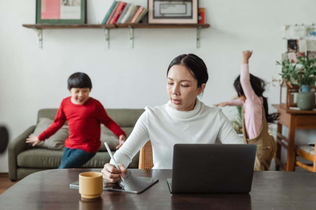 Parent working from home on a laptop enjoying the benefits of working from home with kids