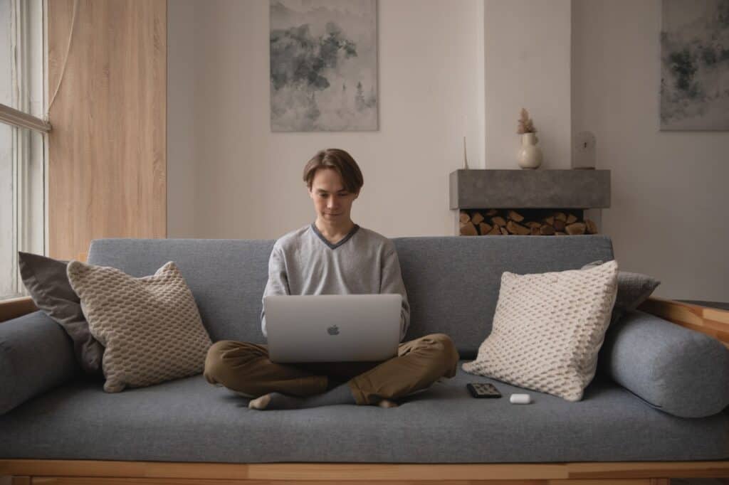 A remote worker working from home on their sofa