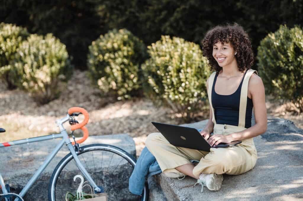 Person working remotely outside on a laptop with their bike